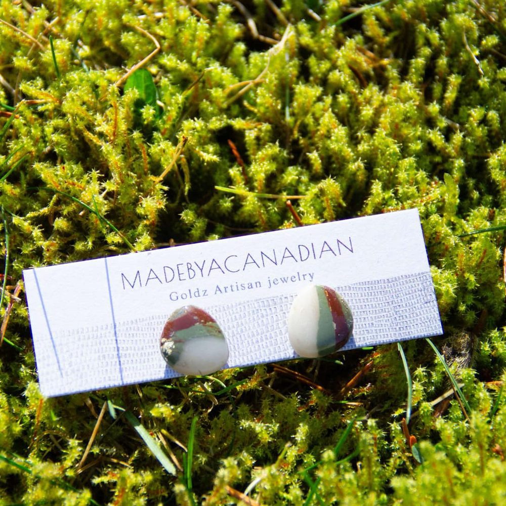 Stone-look clay stud earrings on a Made by a Canadian card, resting on moss